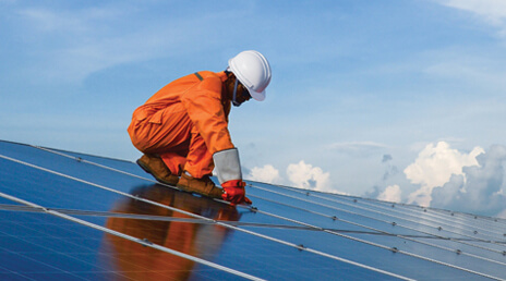 man servicing solar panels